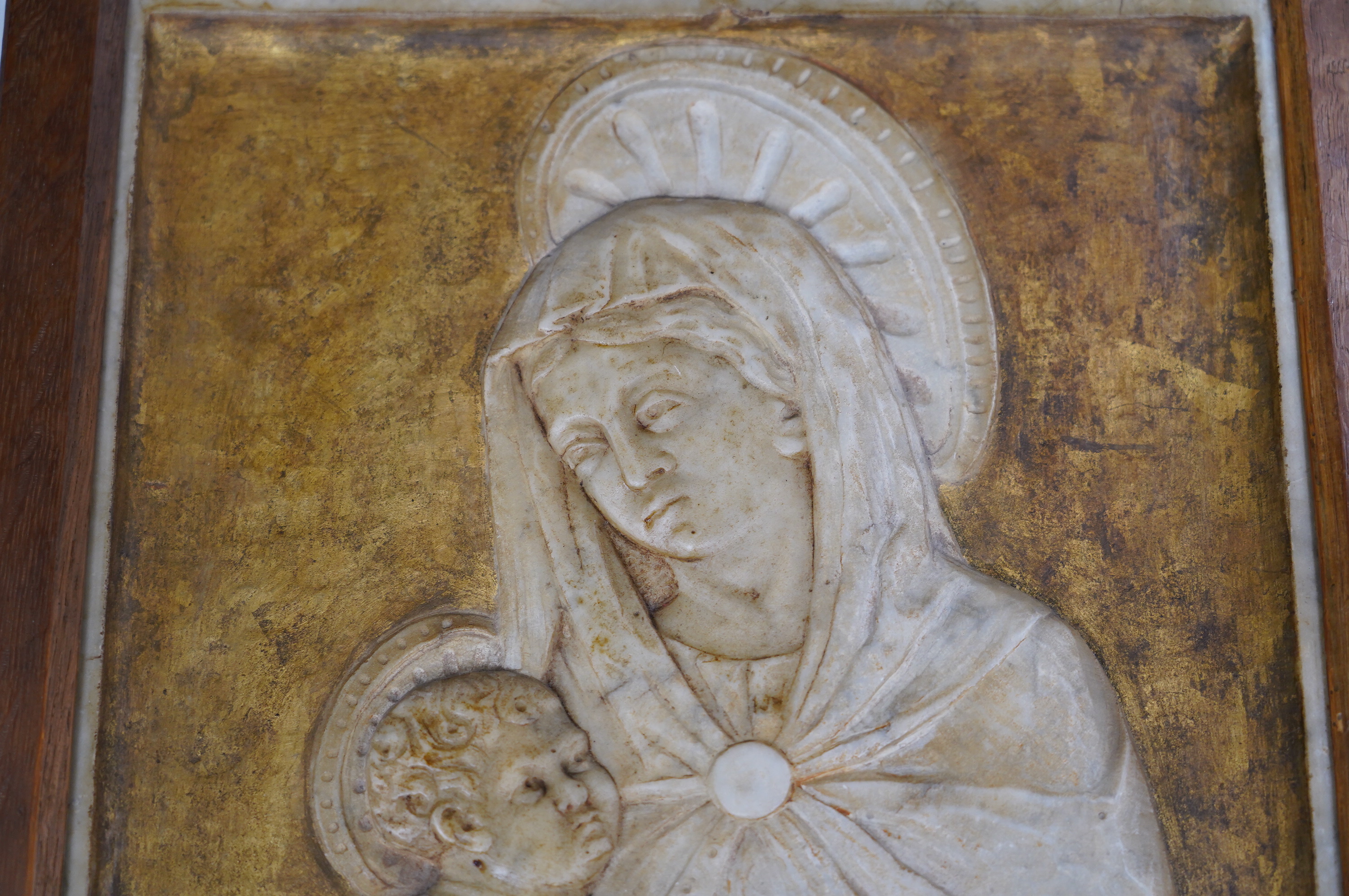 A late 19th century carved alabaster relief of Madonna and child, in an oak frame, frame 50.5cm x 34.5cm. Condition - fair to good